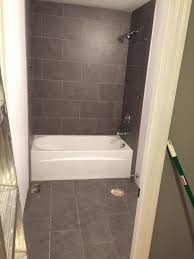 Lowe S Mitte Gray Tile 12x24 Bathroom Tub Surround And Floors Bath Remodel Tile Tub Surround Top Bathroom Design Tub Surround