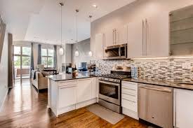 Modern Kitchen And Living Room Space With Hardwood Floors Pendant Lighting Grey Gla White Kitchen Dark Floors Black Granite Countertops Glass Shelves Kitchen