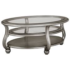 With a durable tempered glass top that pairs seamlessly with a variety of different decor styles. Signature Design By Ashley Coralayne Oval Cocktail Table In Silver Finish With Glass Top Royal Furniture Cocktail Coffee Tables