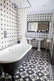 This traditional styled bathroom glossy black floor tiles, with black subway tiles halfway up, with white all the way to the ceiling. Boundary Bathroom Black And White Tiles Bathroom Black And White Bathroom Floor White Bathroom Tiles