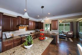 Stainless steel cabinets with metallic backsplash and limestone countertops. Dark Wood Kitchen With Tan Marble Countertops And Light Colored Tile Backsplash Hgtv