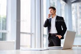Laptop And Documents In Office With Businessman On Background Business Photos Business Man Photo