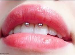 The smiley piercing shows up when you smile or laugh. Sexy Smiley Piercing Closeup Image