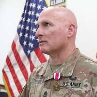 US Air Force Brigadier General Dan Locker (81st Medical Group Commander)  congratulates Retired Technical Sergeant Robert Brunnelle after receiving  his Purple Heart Medal for wounds received 31 years ago while