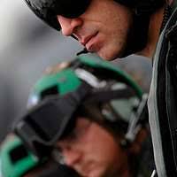 Lt. Cmdr. Eric Akins reads a book to his family through