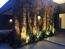 A Iluminacao Direcionada Para A Parde De Pedra Ferro Destacou As Diferencas De Profundidade Deste Revestimento Iluminacao Fachada Fachadas De Casas Fachada