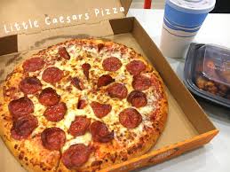 The pizza emerges, fully baked, on the other side, where a second robot arm transfers it to a cutting board, slices it into six pieces, places it in a pizza box, and closes the box. Little Caesars Pizza Skye Soon