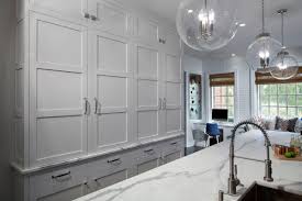 The infusion space with a blue shade will create a relaxed and elegant look. Transitional White Kitchen With Grey Blue Stained Island Crystal Cabinets