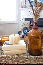 It's just a mum in a sap bucket flanked by two white candlesticks with little pumpkins on top of them. Amber Bottle Fall Vignette Simple Things Matter 2 Bees In A Pod