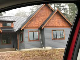 Dark grey siding with white trim, choosing exterior house colors on a lakeside cottage. Grey Exterior Cedar Trim And White Windows