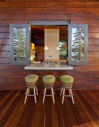 A cozy boho space with a folding window, leather poufs and potted greenery. Terrencephil S Roomporn Collection Kitchen Window Bar Pass Through Kitchen Window Bars