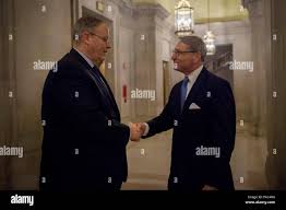 Deputy Secretary of Defense Bob Work is greeted by Tom Stroup President of  the Satellite Industry Association (SIA) as Secretary Work arrives to  deliver remarks at the Satellite Leadership Dinner in Washington,