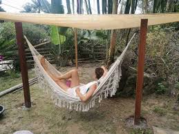 Warped planks transform into an unusual hammock and hang between two large trees. Diy Hammock Stand Outdoor Hammock Area Happy Diy Home