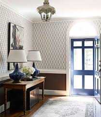 A wall separating the master bedroom from the double height living space was replaced with a folding glass door to open the bedroom to the living space while still allowing for both visual and acoustical privacy. Quatrefoil Wallpaper Eclectic Entrance Foyer House Beautiful