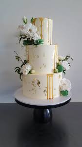 Cake by flour cake studio & flax flowers by flaxation. Three Tier Buttercream With Gold Leaf Caramel Sauce Green Macarons And Fresh White Flowers Gold And White Cake Gold Wedding Cake Wedding Cakes
