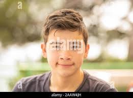 Close up portrait of a young teenager man looking at camera with a  wondering expression