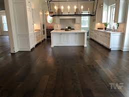 A varied tile backsplash and white cabinets were chosen to pair with the flooring, and overhead exposed beams featuring dark wood mirror what's below. Thinking Of Staining Your Hardwood Floors A Dark Color