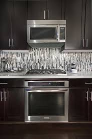 To Accentuate The Modern Lines Within We Laid The Quartz Metal And Glass Backsplash Tile Modern Kitchen Backsplash Kitchen Tiles Backsplash Glass Backsplash