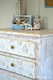 The chipped white paint, paired with a distressed brown wood top is simply striking for lovers of cottage chic style. White And Gold Distressed Damask Dresser