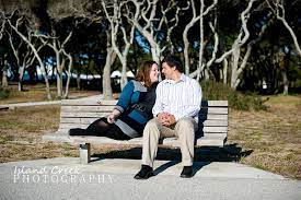 Couple Poses On Benches Couple Poses On A Park Bench In Front Of Twisted Oak Trees During For Engaged Couples Photography Poses On Bench Couple Picture Poses