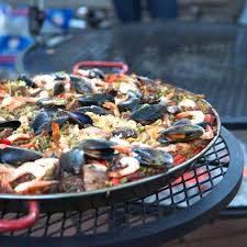 Paella may be considered a complete dish by itself, but that doesn't mean that you can pair it with other side dishes. Rally Your Friends Throw An Outdoor Paella Party This Summer Paella Party Paella Party Catering