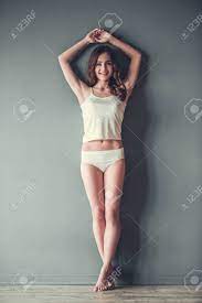 Full Length Portrait Of Beautiful Young Girl In White Underwear Looking At  Camera And Smiling, On Gray Background Stock Photo, Picture and Royalty  Free Image. Image 77692882.