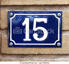 Number 15. The number 15 in white on a vibrant blue metal plaque screwed to  a concrete outdoor wall. | CanStock