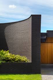 Very few people are aware of the benefits that they offer to their residents. This Home Combines A Black Brick Exterior With Large Glass Walls For A Strong Contemporary Design