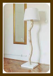 A natural floor lamp with a base made of branches and a simple fabric lampshade hanging. Cool Diy Tree Branch Lamp Tutorial Family Focus Blog