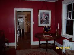 Dramatic red dining room with ebony finished floor, red walls and ceiling , dining room side chairs and 2 wing chairs are upholstered in dark chocolate brown mohair, large area rug is custom in red with dark brown greek key border. Dining In The Garden Room Revisions