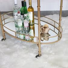 Get 5% in rewards with club o! Gold Mirrored Oval Drinks Trolley
