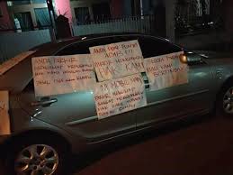 Dari kedua foto tersebut terlihat sebuah mobil mewah berwarna hitam terparkir di depan sebuah rumah yang bisa dibilang cukup mewah. Parkir Sembarangan Mobil Jadi Sasaran Kekesalan Warga