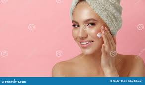 Smiling Young Woman with Clean Skin Applies Cream