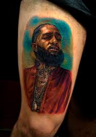 Nipsey's face is tattooed onto lauren's arm with the quote: 61 Hussle Tattoo