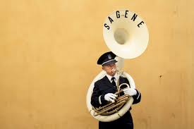 The sousaphone's shape is such that the bell is above the tubist's head and projecting forward. En Sousafonist Blaser Ut Morgenbladet