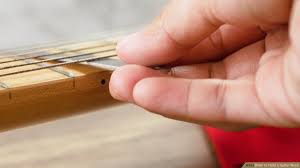 The thumb is placed in the middle on the back of the guitar neck. 3 Easy Ways To Hold A Guitar Neck Wikihow