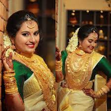 South Indian Hindu Bride Wearing A Traditional Kerala Saree With Mullapoo Jasmine Flowers And Gold Jewellery For The Thali Hindu Bride Saree Kerala Saree