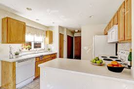 This option is a high end interiors solution, for high budget interiors. Simple Kitchen Interior In Bright White Color With Wooden Cabinets Stock Photo Picture And Royalty Free Image Image 31658779