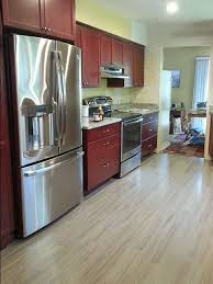 Blue paint and cherry wood floors were made for each other. Grey Hardwood Floors Accent A Modern Kitchen With Cherry Cabinets And Stainless Steel Appliances R Kitchen Remodel Small Kitchen Remodel Cherry Wood Cabinets