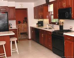 Traditional Medium Wood Cherry Kitchen Cabinets With Black Appliances Cherry Cabinets Kitchen Kitchen Cabinets With Black Appliances Kitchen Dining Room Combo