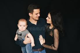 Familia Caucasica Joven En Un Fondo Negro Papa Mama E Hijo Felices Pareja De Amor Que Detiene A Un Nino Imagen De Archivo Imagen De Blanco Fondo 141314271