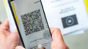 Ein mann scannt mit einem handy ein dokument für den digitalen impfnachweis. Q8i6 Rnqlcsomm