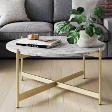It has a smooth, gray laminate top and black metal, open frame legs. Piper White Faux Marble Gold Brass Metal Frame Round Modern Living Room Coffee Table Nathan James