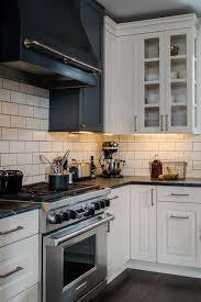 Beautiful Kitchen With White Raised Panel Cabinets Paired With Brass Hardware And Soapsto White Kitchen Tiles Grey Grout White Kitchen Tiles Lake House Kitchen