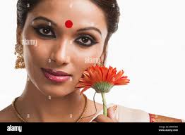 Bengali Frau, die eine Daisy Blume lächelnd Stockfotografie