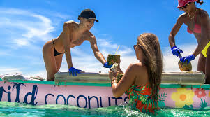People enjoying drinks from a floating vendor boat at Crab Island sandbar near Destin, Florida on the Emerald Coast