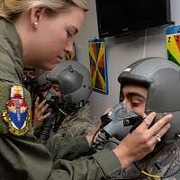 U.S. Navy Aircrew Survival Equipmentman 1ST Class James Dickerson (back),  Strike fighter Squadron 106 (VFA-106, ΦGladiatorsτ), fits Ms. Laura  Ingraham (front), Radio Talk Show Host and Author, into her flight gear  prior