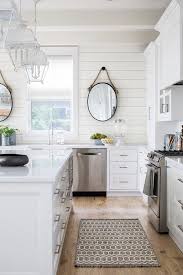 This light and bright kitchen looks readymade for baking fests and features views out onto the front yard. White Cottage Kitchen With White Lanterns Cottage Kitchen