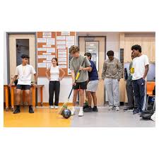In Matt Dilley's Grade 9 Physics class, students participated in a bowling  ball and broom relay race yesterday. Using broom bristles, they guided a  bowling ball across the floor of their Annex