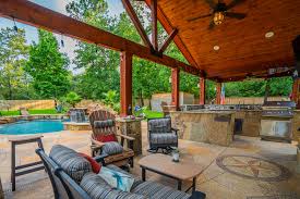 Stone pavers are used throughout the space to create gentle slopes, making it easier to navigate for a homeowner. Custom Outdoor Kitchen Bar Contractors North Houston Backyard Oasis